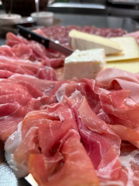 Tagliere di prosciutto crudo affettato sottile con formaggi